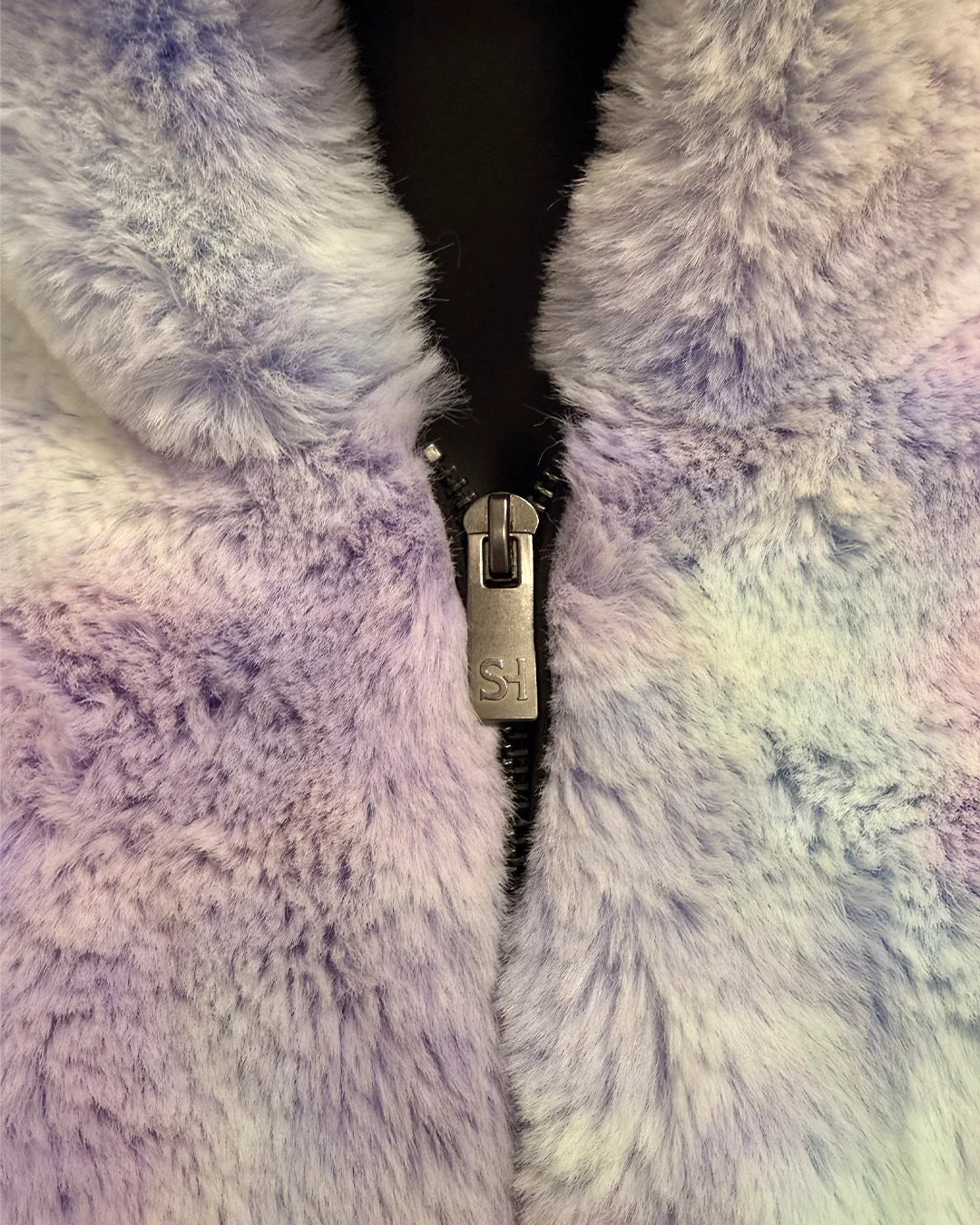 Close-up of a fluffy, multicolored fabric with a zipper running through it.
