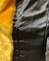 Close-up of a black satin lining in the Golden Wolf Faux Fur jacket with yellow fur trim