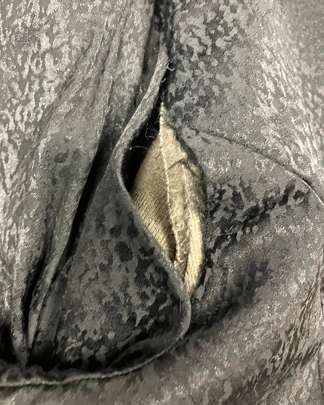 Close-up of torn inner left arm seam.