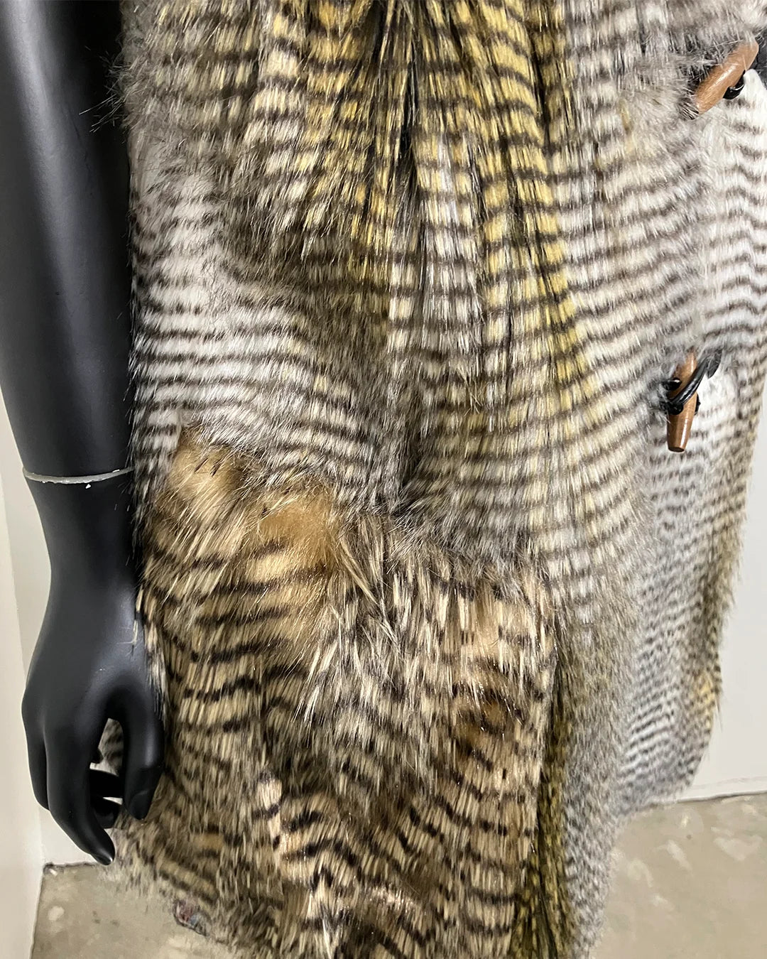 Mannequin wearing a textured hawk inspired faux fur vest with a plain background