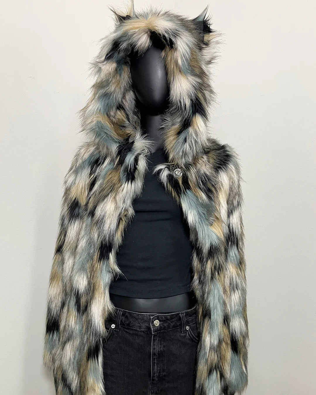 Multicolored faux fur coat with hood on a mannequin against a white background