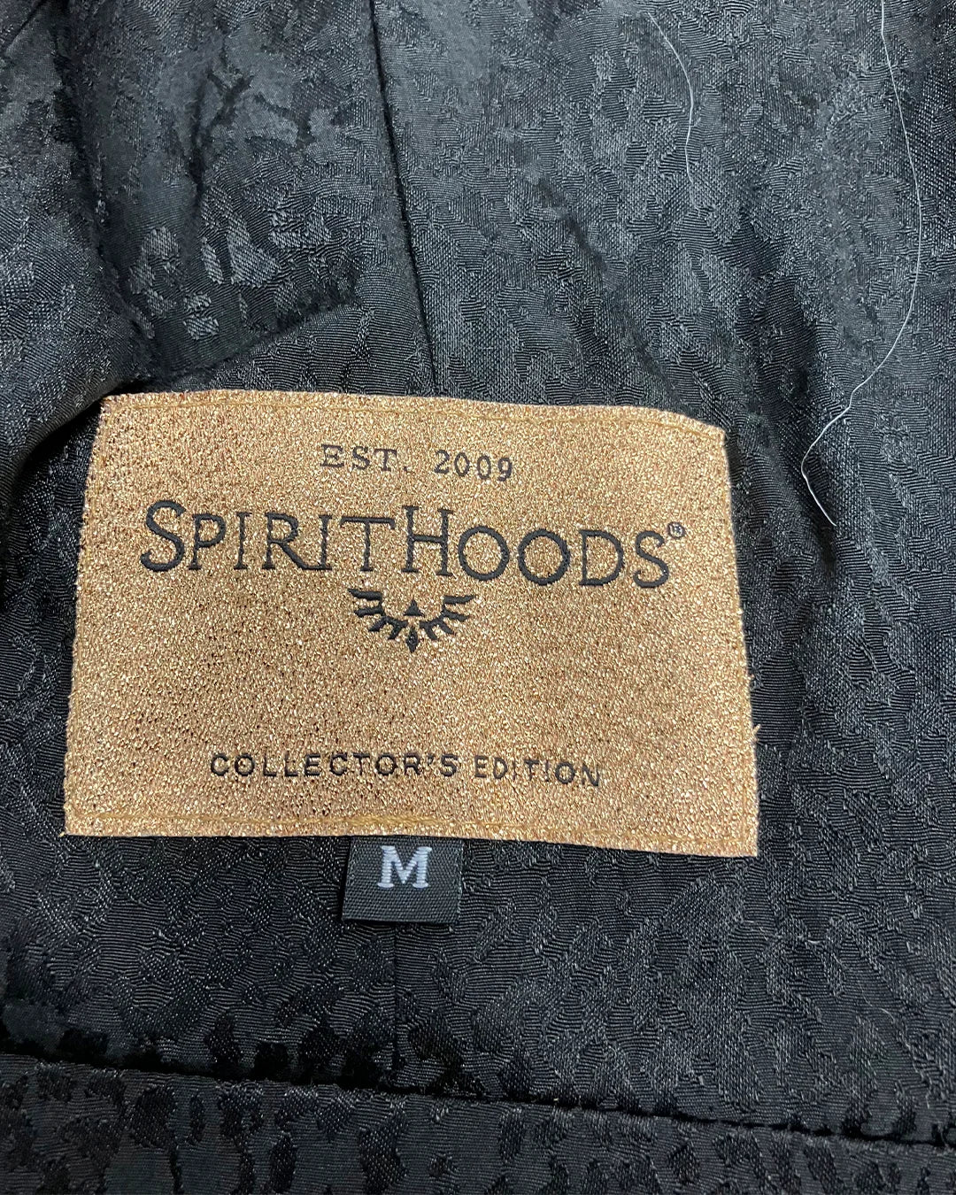 Spirithoods label on a dark textured fabric background