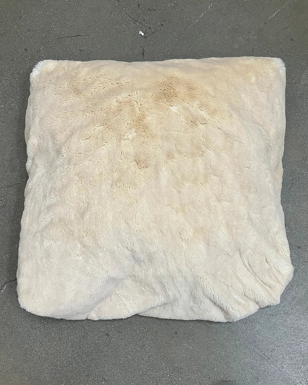 White pillow with brown stains on a gray background