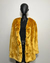 Mannequin wearing a mustard yellow fake fur coat against a plain background