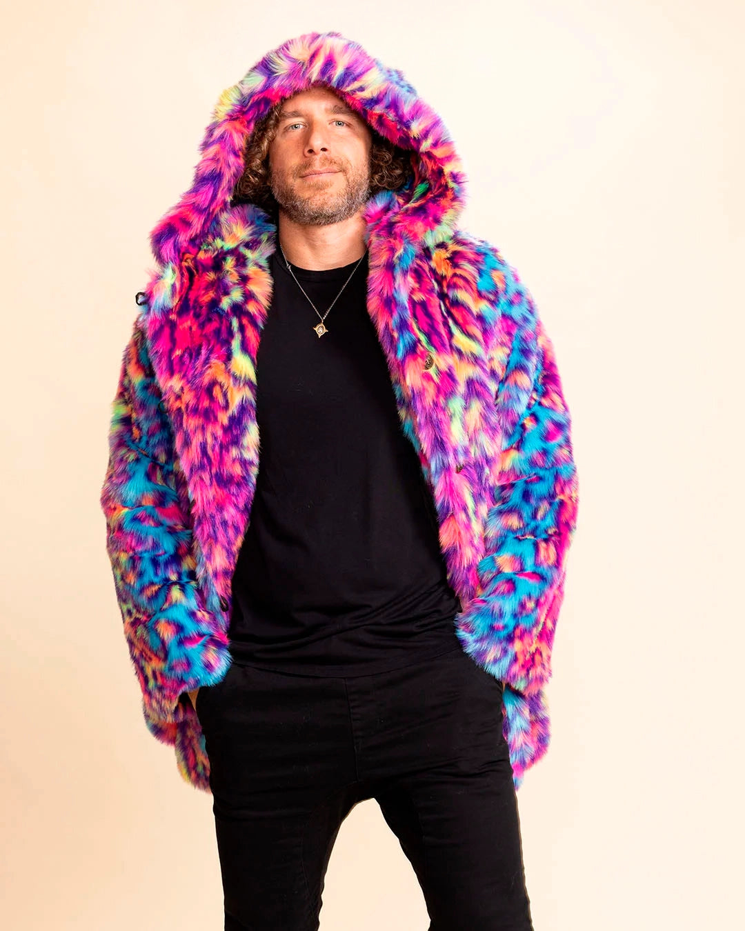 A Man smiling at the camera, with his hands in his pockets, wearing a colorful faux fur coat with neon tie-dye animal print throughout the fake fur jacket. SpiritHoods Mens Fall Custom Made Coats and Faux Fur Jackets - limited waste made to order production