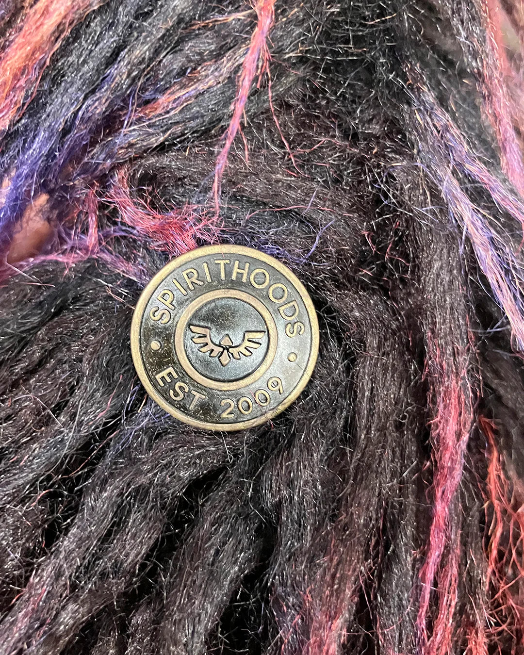 Bronze button with 'SpiritHoods' logo on textured plush fake fur vest alpaca inspired fur