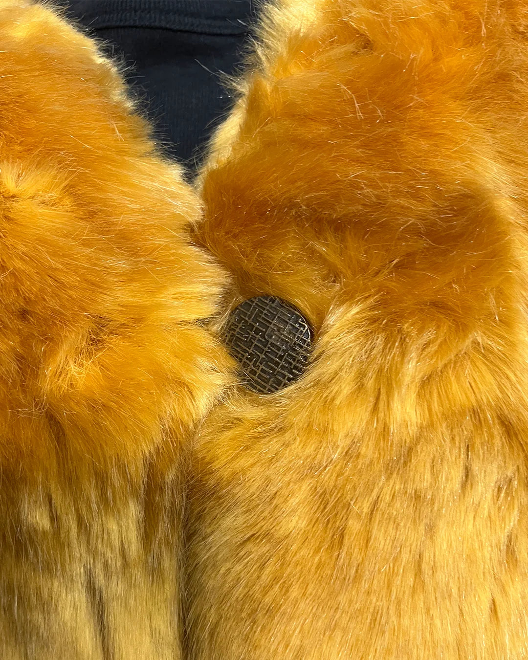 Close-up of a fake fur garment with a button detail