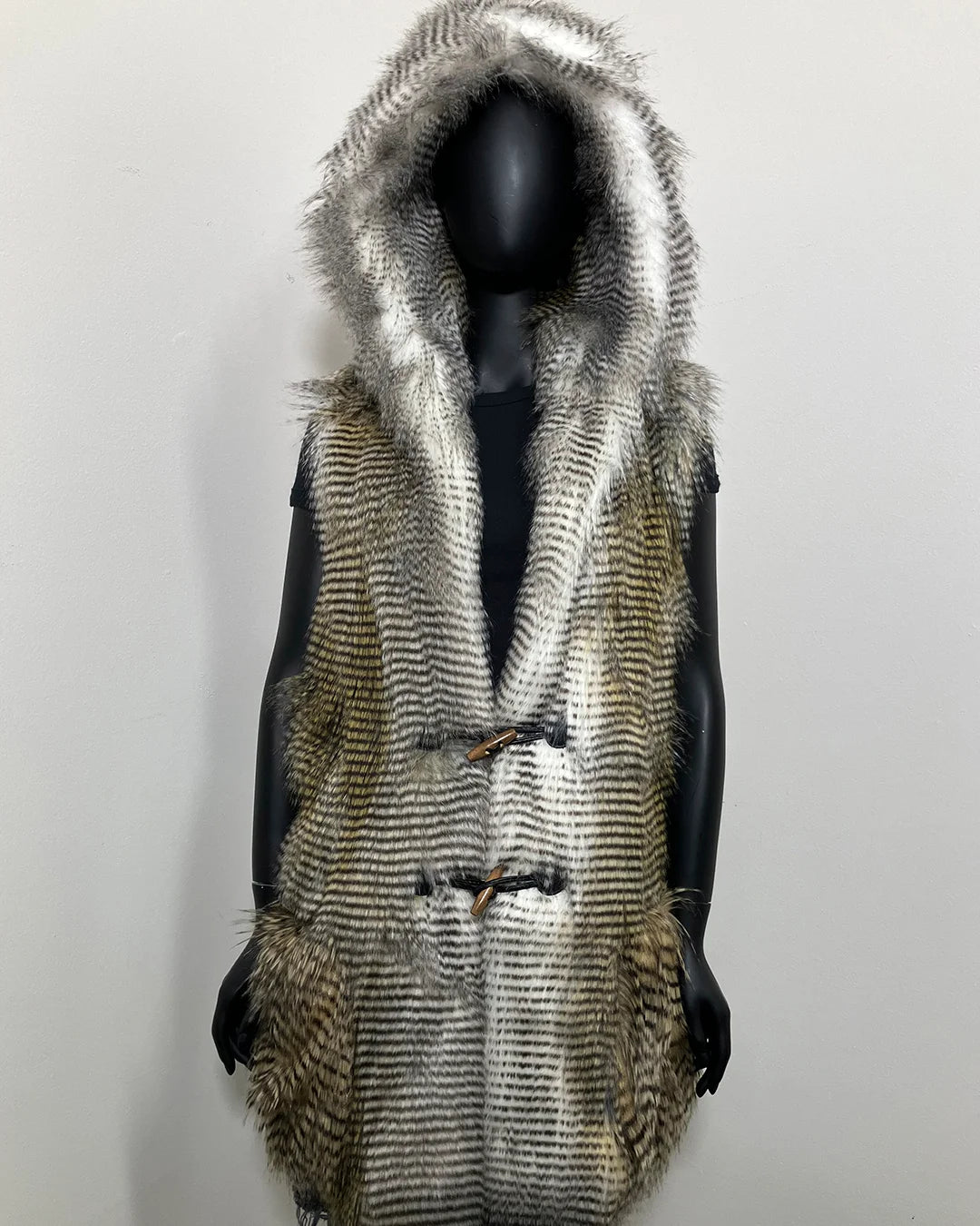 Mannequin wearing a faux fur vest with a hood on a plain background. SpiritHoods Online Sample Sale Style: Hooded Faux Fur Vest in Alaskan Hawk - Size Medium.