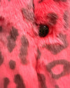 Close-up of a pink plush faux fur coat with a leopard face button 