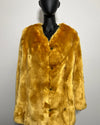 Yellow fake fur coat on a mannequin against a plain background