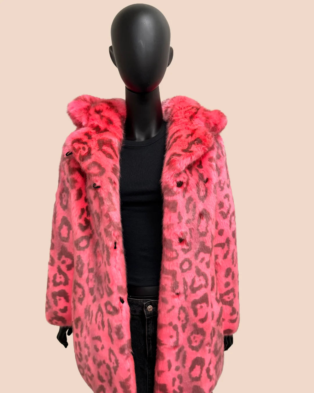 Mannequin wearing a pink leopard print coat on a beige background