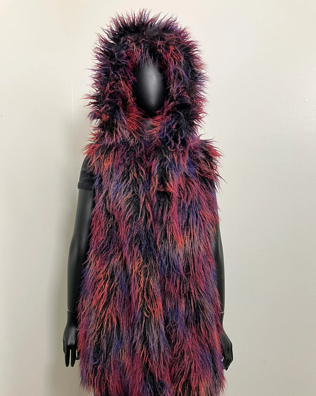 Multicolored fake fur vest on a mannequin against a plain background