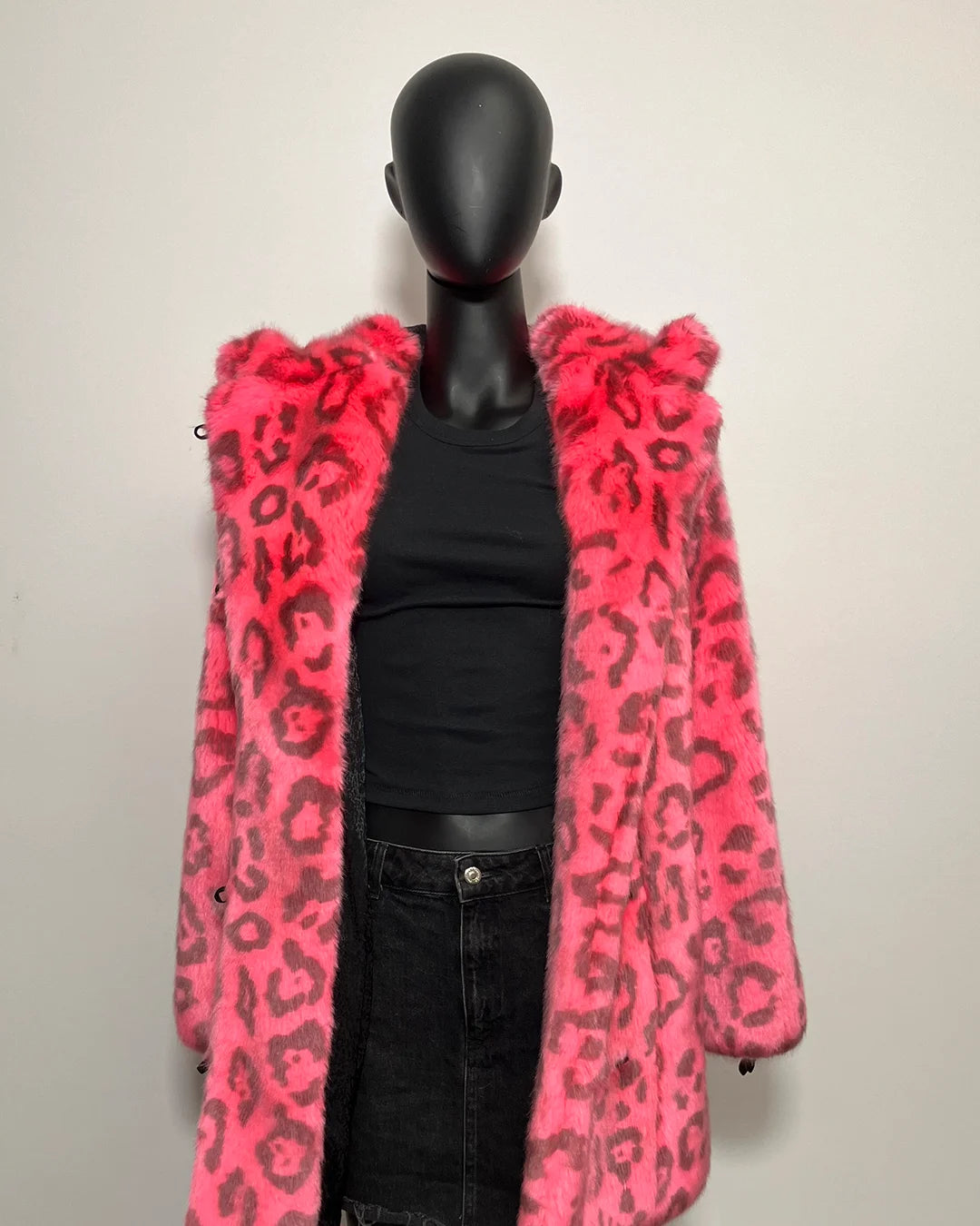 Mannequin wearing a pink leopard print coat against a plain background
