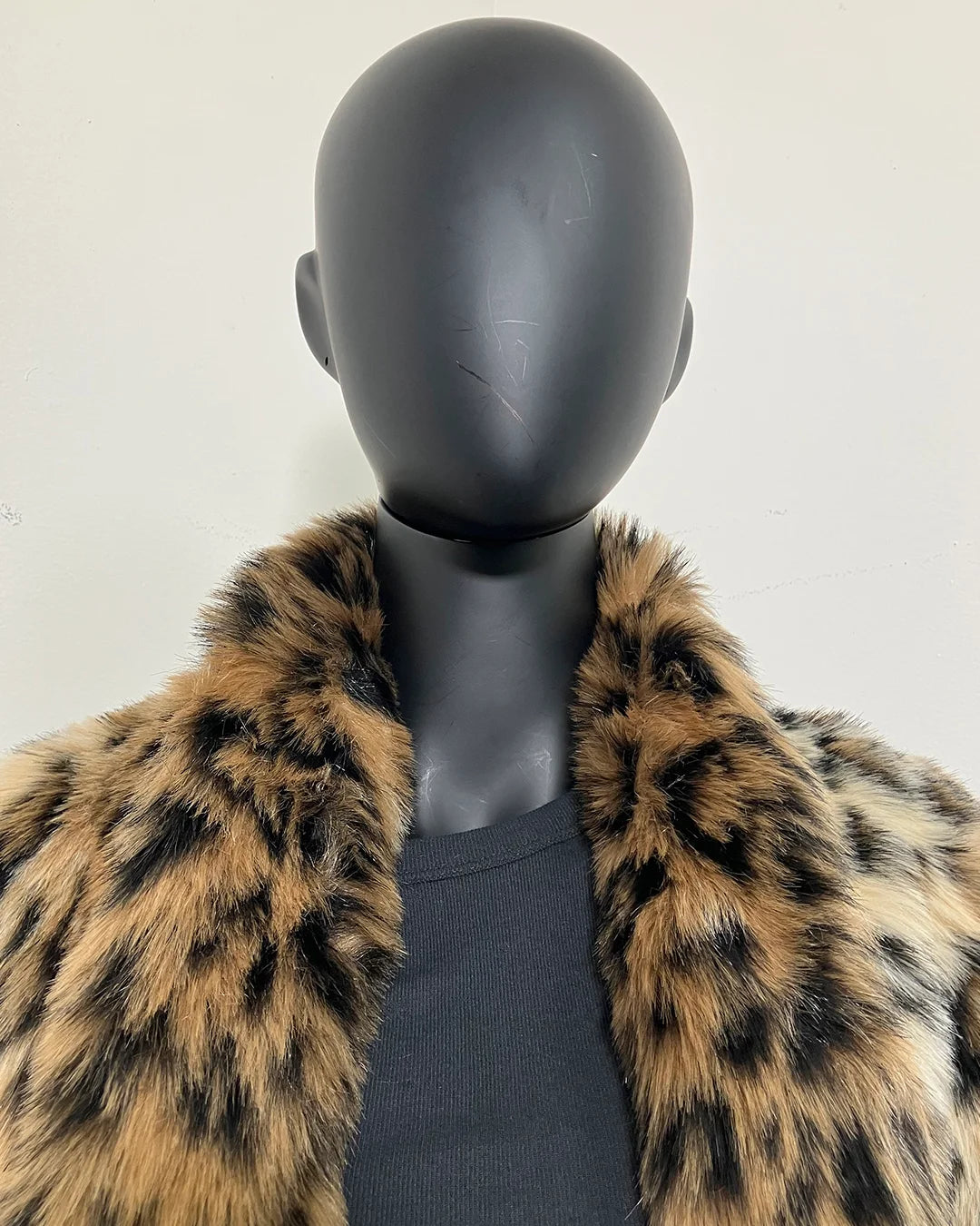 close-up photo of the leopard faux fur coat collar being worn down on the mannequin. SpiritHoods Online Sample Sale Faux Fur Coat in Leopard Print in Size MEDIUM.