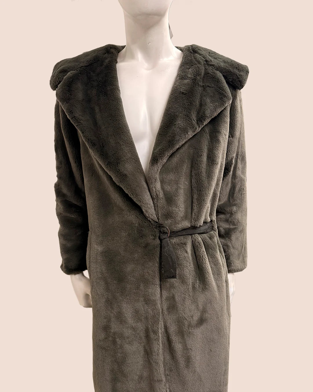 Mannequin wearing a gray fake fur wrap coat with a hood on a plain background