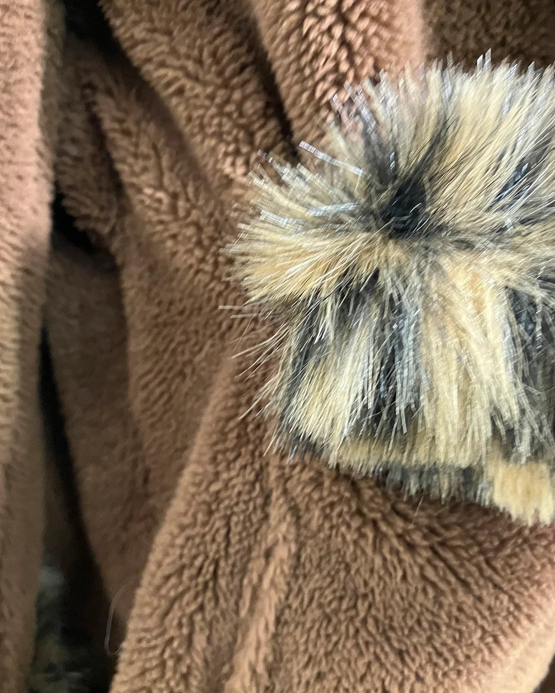 close-up photo of the brown body fabric of the leopard short robe with faux fur trim on the pocket
