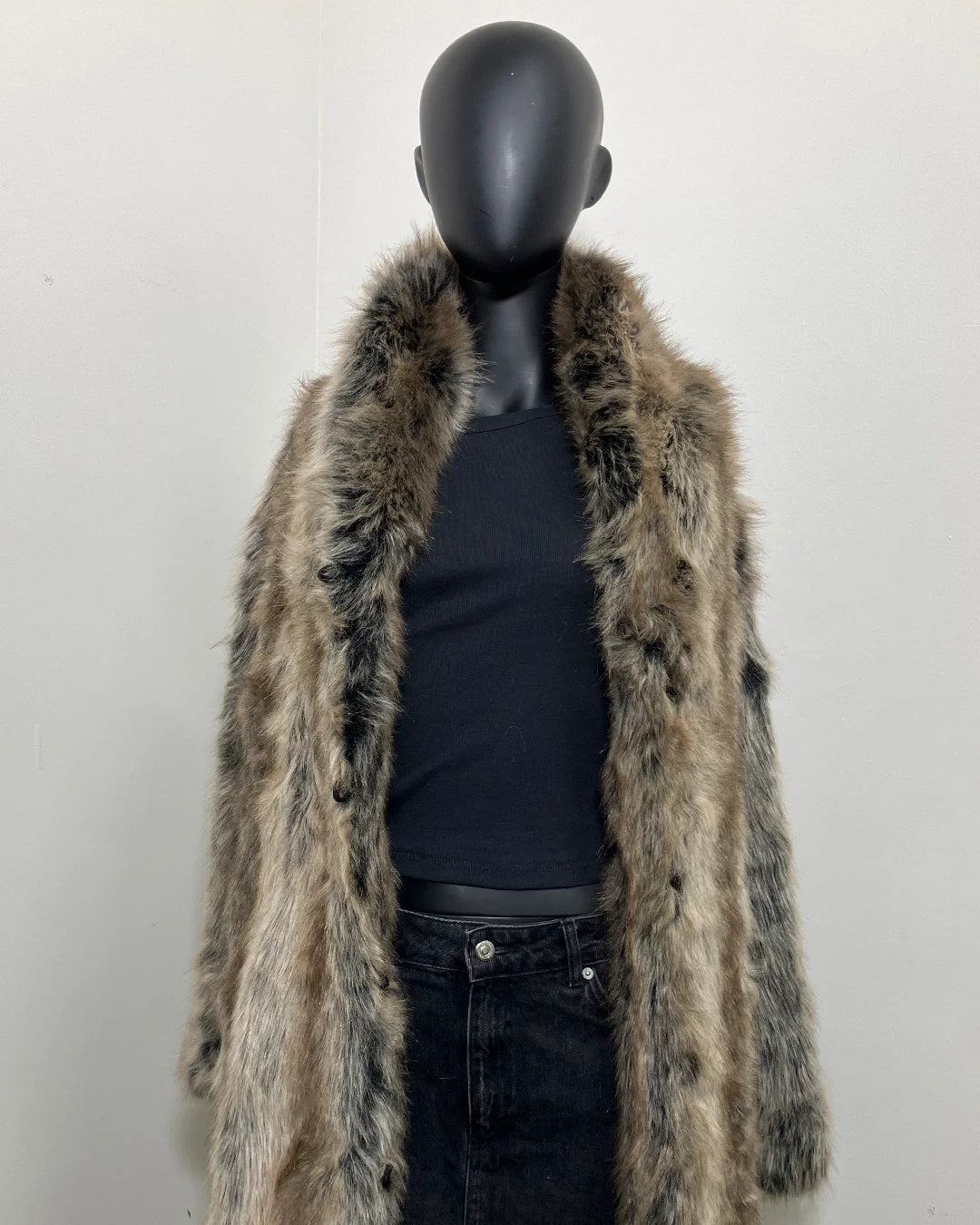 Mannequin wearing a grey fake fur coat with a plain background