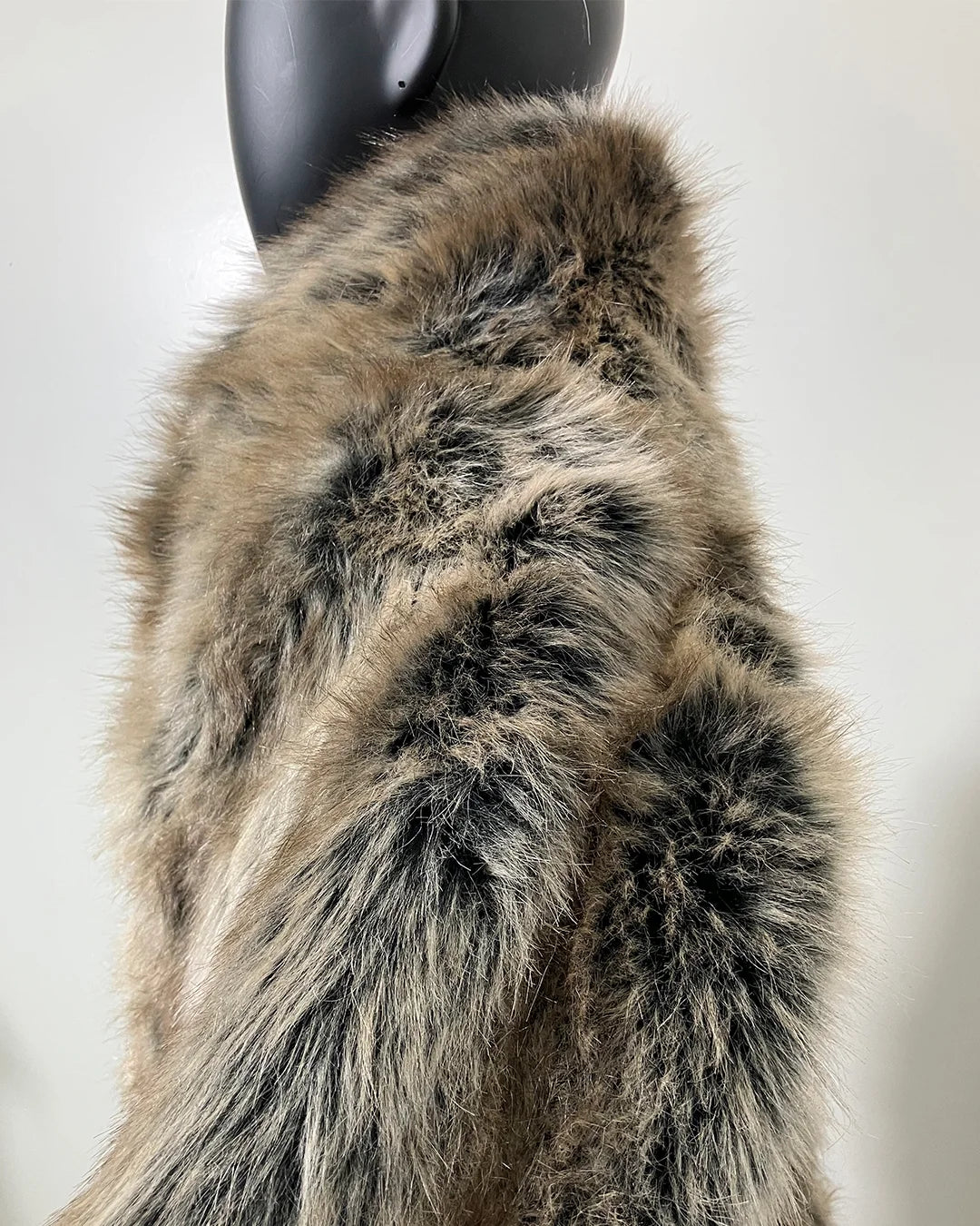 Close-up of a fur coat on a mannequin against a neutral background