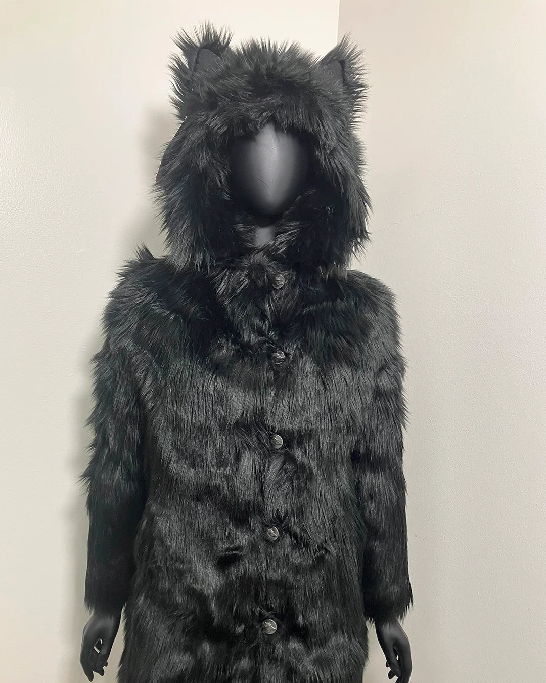 Black faux fur coat with hood on a white background, showing the slight creasing throughout this xxs sample sale coat style