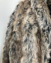Close-up of a fake fur coat with a neutral color palette on a white background