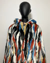 Multicolored faux fur coat on a black mannequin against a white background