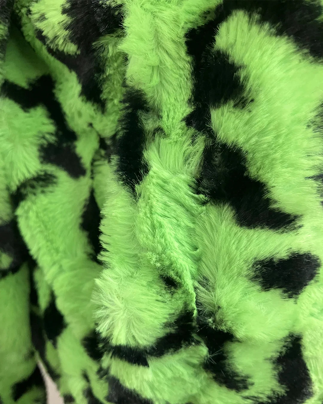 close up photo of the short pile faux fur neon green leopard print faux fur on the bomber jacket