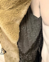 Close-up of a green faux fur coat with a spirithoods logo liner and inner zipper pocket