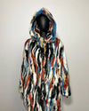 Multicolored fake fur coat on a mannequin against a plain background