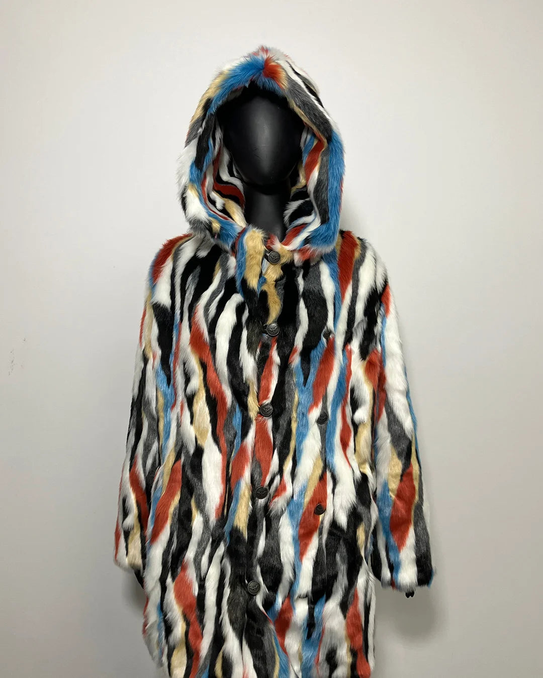 Multicolored fake fur coat on a mannequin against a plain background