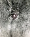Close-up photo of the custom wolf face button on the hummingbird faux fur coat. 