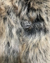 Close-up of a plsuh fake fur jacket with the wolf face button closure