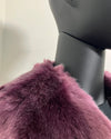 Close-up of a purple faux fur v-neck coat on a mannequin against a neutral background