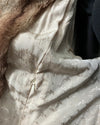 Close-up of a textured spirithoods logo liner in the cougar faux fur long wrap coat 