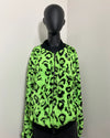 Neon green leopard faux fur bomber jacket on a mannequin against a white wall