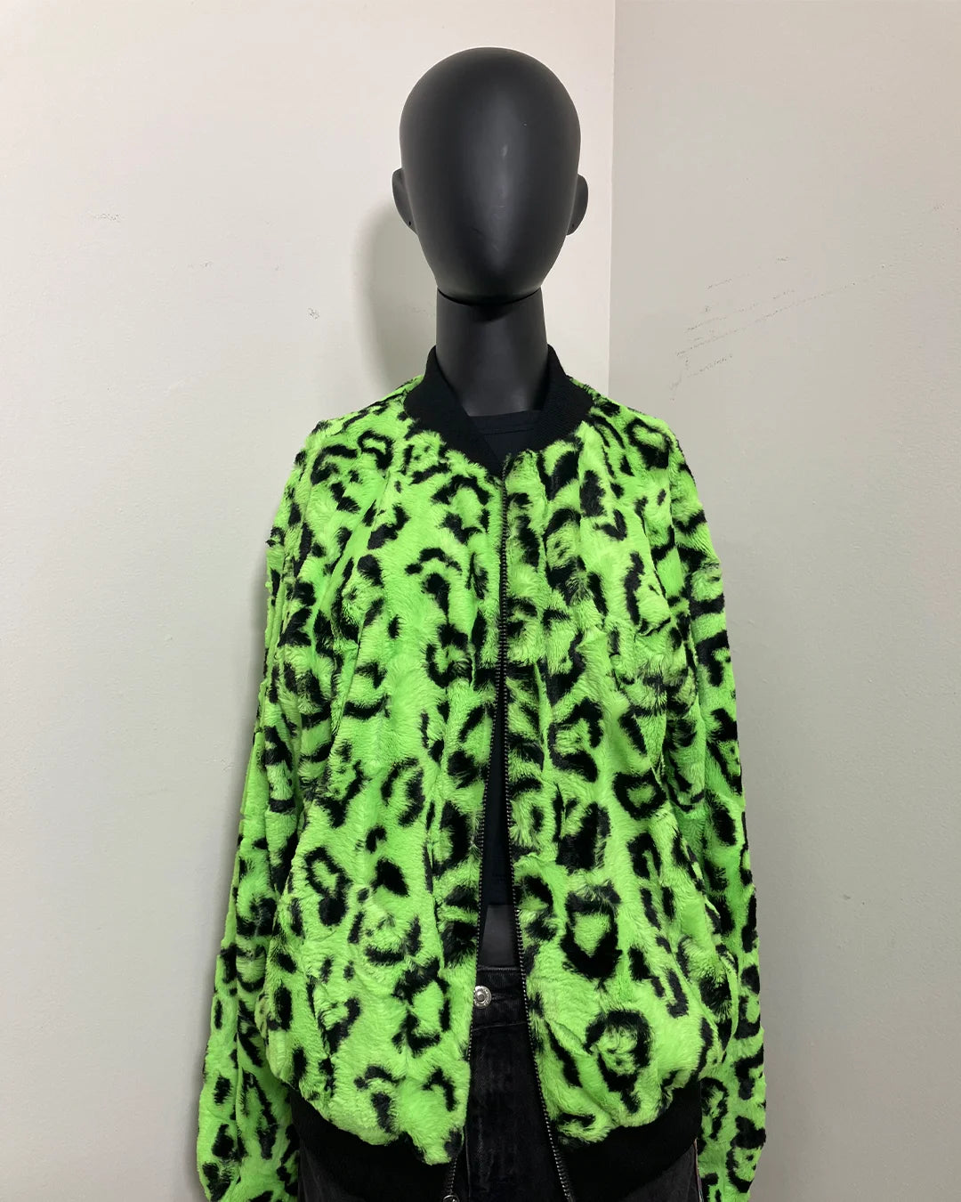 black mannequin wearing spirithoods colorful faux fur bomber jacket with a zipper and neon green leopard print short pile fake fur.