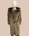 green faux fur coat with hood on a mannequin against a beige background