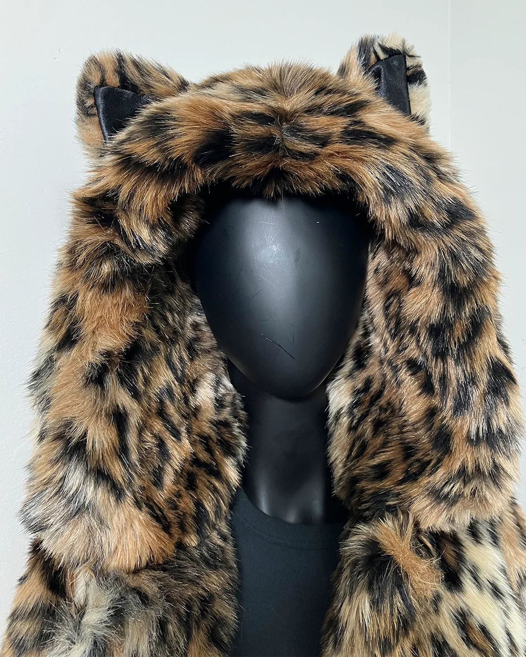 Leopard print faux fur coat on a mannequin against a white background