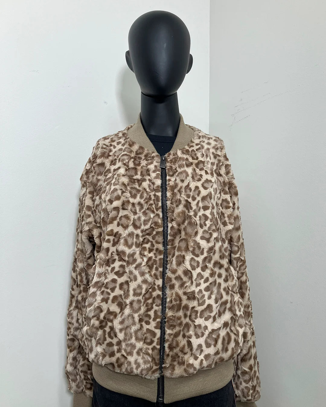 photo of a mannequin wearing the tan leopard print bomber jacket featuring a short pile beige and brown leopard print on a zipper bomber jacket with faux fur.