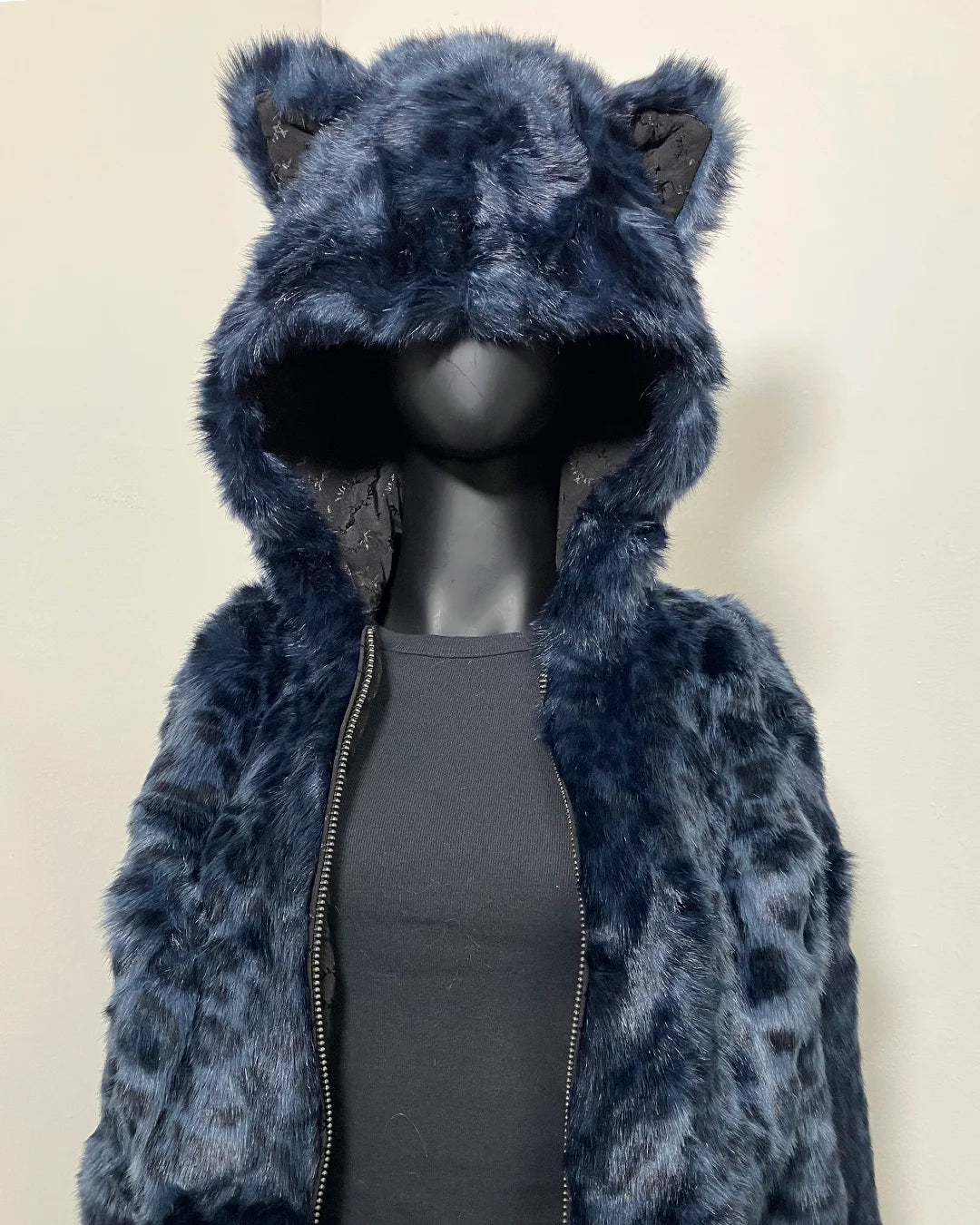 Blue faux fur cropped jacket with animal ears on a mannequin against a beige background