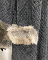 close-up photo of the grey wolf faux fur fabric trim on the outer robe pocket and the black clouded double-sided body fabric