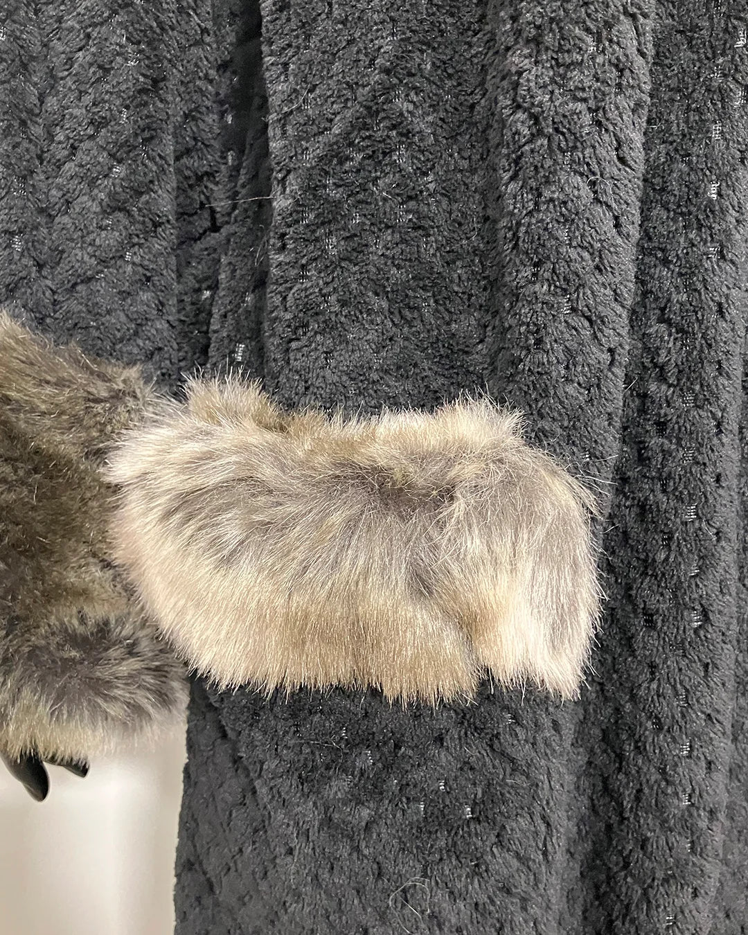 close-up photo of the grey wolf faux fur fabric trim on the outer robe pocket and the black clouded double-sided body fabric