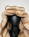 Brown fake fur coat with hood on a mannequin against a gray background