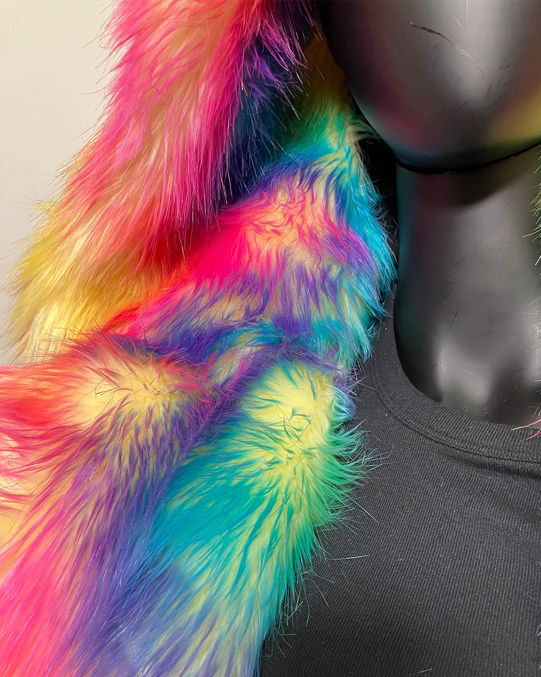 Mannequin wearing a colorful fake fur coat with a neutral background