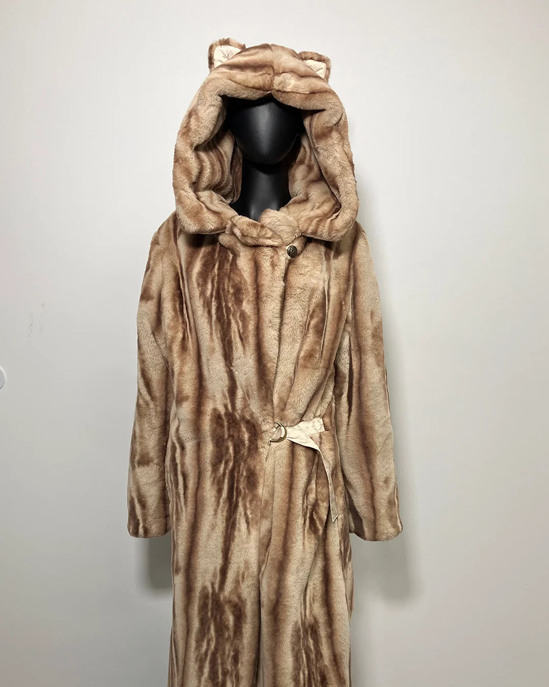 Brown fake fur coat with hood on a mannequin against a white background