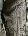 Close-up of a textured fabric with a pattern, possibly a dress or garment.