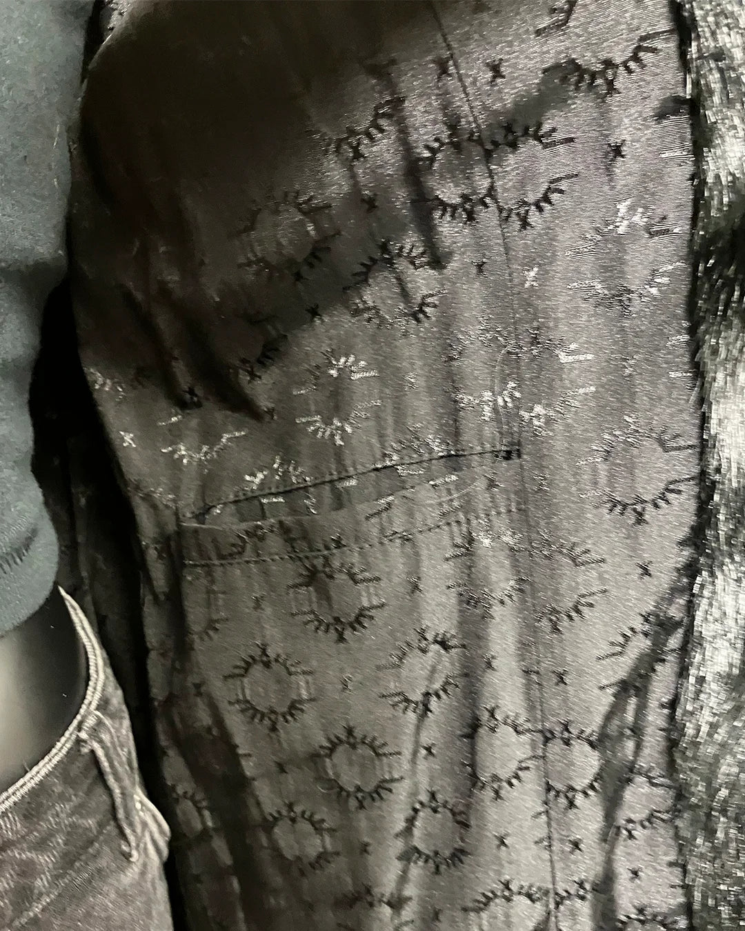 Close-up of a textured fabric with a pattern, possibly a dress or garment.