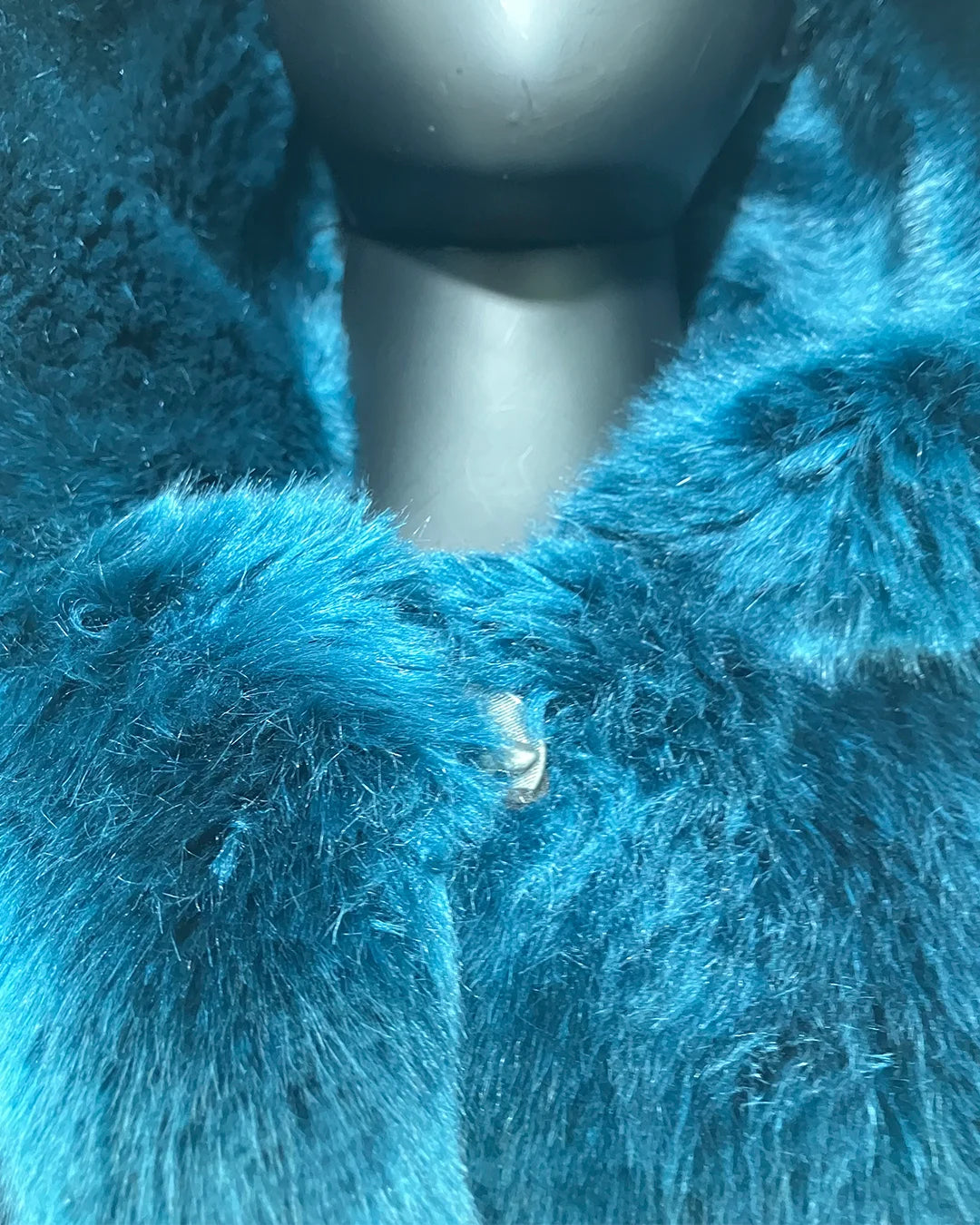 Close-up phot of the blue faux fur and wolf face button