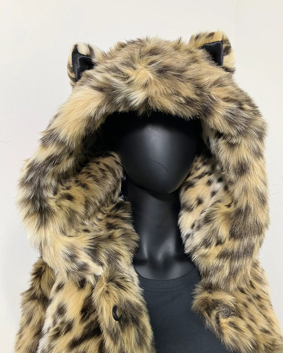 Mannequin wearing a cheetah print fake fur coat with a hood on a white background