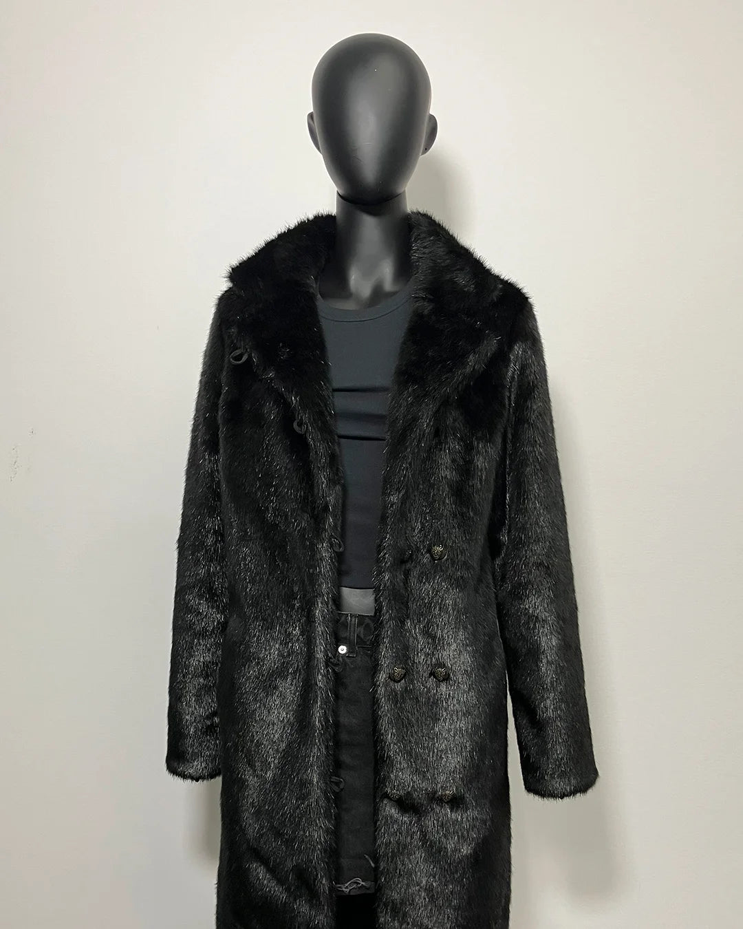 Mannequin wearing a black faux fur coat on a white background