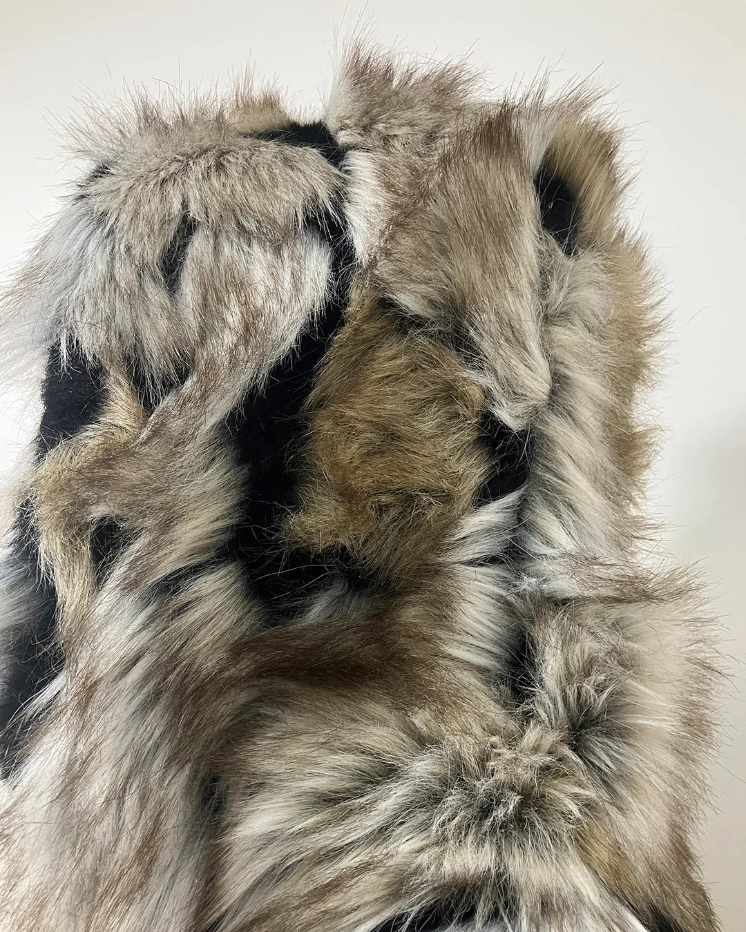 Close-up of a area of faux fur  that is not as soft as SpiritHoods Standard Quality with a neutral color palette on a light background. SpiritHoods Online Sample Sale - Wolverine Coat in size SMALL